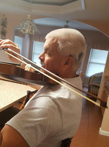 Dante playing violin after decision to get a cochlear implant