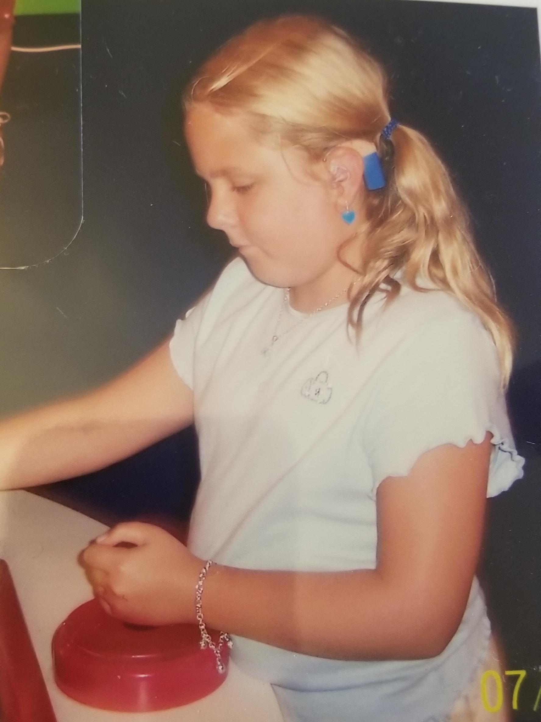 Savannah, a young adult with cochlear implants, as a child