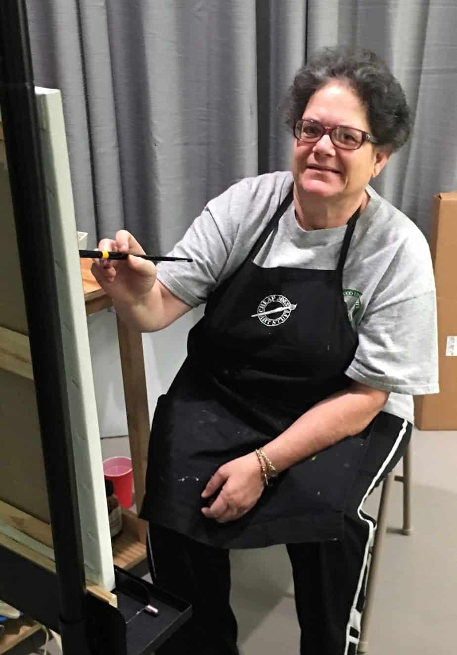 Rose, an artist with hearing loss, painting