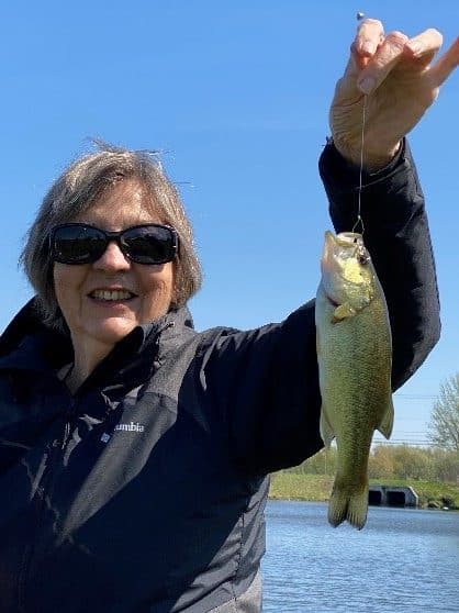 Mary Ann shows off a fish she caught. Smiling she is happy she now has the Kanso 2 upgraded from Nucleus 7