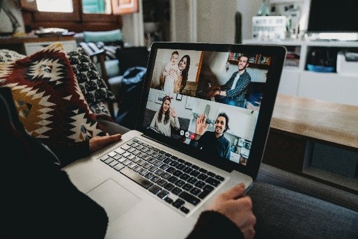 Video calls can leave you with listening fatigue. This image of a person holding a laptop on a video call demonstrates that.