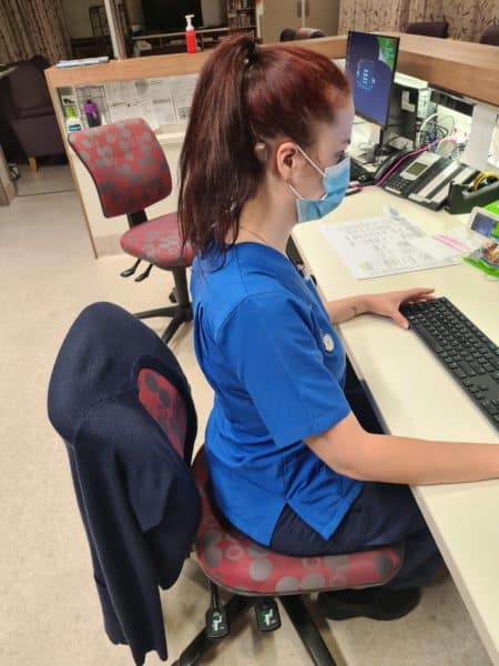 Alisha sits at her desk proud of her bilateral Baha 5 and how they help her hearing
